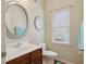 Well-lit bathroom with a vanity, mirror, and toilet, showcasing a functional design at 895 Mill Garden Pl, Cumming, GA 30040