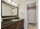 This bathroom features a dark vanity with a large mirror and modern lighting fixture above at 895 Mill Garden Pl, Cumming, GA 30040