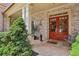Inviting front porch with brick flooring, double red doors, and outdoor seating at 895 Mill Garden Pl, Cumming, GA 30040