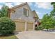 Spacious two-car garage with brick accents, and driveway at 895 Mill Garden Pl, Cumming, GA 30040