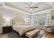 Bright main bedroom featuring tray ceilings, a ceiling fan, and large bay windows at 895 Mill Garden Pl, Cumming, GA 30040