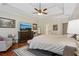 Bright main bedroom featuring tray ceilings, a ceiling fan, and a large dresser at 895 Mill Garden Pl, Cumming, GA 30040