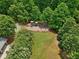 Aerial view of community playground with slide, swings, and adjacent sport court surrounded by lush greenery at 895 Mill Garden Pl, Cumming, GA 30040