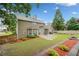 Expansive yard with patio, manicured lawn, garden beds, and mature trees at 977 Frog Leap Trail Nw, Kennesaw, GA 30152
