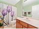 Well-lit bathroom with floral shower curtain, vanity, and neutral-toned walls at 977 Frog Leap Trail Nw, Kennesaw, GA 30152