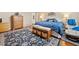 Spacious bedroom with hard wood floors, patterned rug, and relaxing recliner at 977 Frog Leap Trail Nw, Kennesaw, GA 30152
