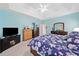 This is a beautiful bedroom with a tray ceiling, black TV console and floral bedding at 977 Frog Leap Trail Nw, Kennesaw, GA 30152