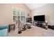 Comfortable living room space with vaulted ceiling, large windows, and comfortable furnishings on carpeted floor at 977 Frog Leap Trail Nw, Kennesaw, GA 30152