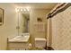 Clean bathroom with a single vanity, toilet, and shower with patterned curtain, offering essential amenities at 1818 Mcconnell Rd, Grayson, GA 30017