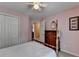 Cozy bedroom with pink walls, ceiling fan, and dark wood furnishings, creating a warm inviting space at 1818 Mcconnell Rd, Grayson, GA 30017