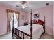 Bedroom with pink walls, a four poster bed, and natural light from the window at 1818 Mcconnell Rd, Grayson, GA 30017