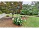 Green front yard with mature trees and a flower bed at 1818 Mcconnell Rd, Grayson, GA 30017