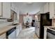A classic eat-in kitchen featuring white cabinets, tile flooring, and a stainless-steel refrigerator at 1818 Mcconnell Rd, Grayson, GA 30017