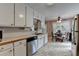 Bright eat-in kitchen showcasing white cabinets, tile flooring, and modern stainless steel appliances at 1818 Mcconnell Rd, Grayson, GA 30017