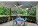 Covered patio with outdoor table and chairs overlooking lush greenery and mature hedges at 1818 Mcconnell Rd, Grayson, GA 30017