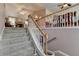 Carpeted stairs with white and wood railings lead to an open space, enhancing the home's inviting atmosphere at 1818 Mcconnell Rd, Grayson, GA 30017