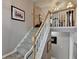 A carpeted staircase with wood and white railing leads to the second level, offering a view of the open floor plan at 1818 Mcconnell Rd, Grayson, GA 30017