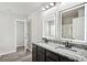 Bright bathroom featuring double vanity with granite counters and illuminated mirrors at 2493 Oakleaf Rdg, Lithonia, GA 30058