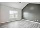 Spacious bedroom with a window, vaulted ceilings, gray accent wall and light-colored hard wood flooring at 2493 Oakleaf Rdg, Lithonia, GA 30058