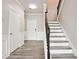 Welcoming foyer features gray plank flooring, white trim, staircase with dark railings, and a door at 2493 Oakleaf Rdg, Lithonia, GA 30058