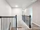 Hallway with dark wood railings, black metal balusters, and light wood floors leading to the various rooms at 2493 Oakleaf Rdg, Lithonia, GA 30058