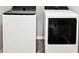 Modern white washer and dryer on gray plank flooring in laundry area at 2493 Oakleaf Rdg, Lithonia, GA 30058