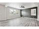 Open living room with hardwood floors, ceiling fan, and dark accent wall at 2493 Oakleaf Rdg, Lithonia, GA 30058