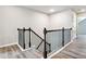 Staircase with dark wood railings, black metal balusters, and light wood floors leading to the upper level at 2493 Oakleaf Rdg, Lithonia, GA 30058