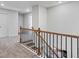 Carpeted upstairs hallway with stairs that have black wrought iron and wood bannister at 49 Ryder Pass Way, Loganville, GA 30052