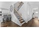Elegant staircase with hardwood steps and a decorative wrought iron railing at 49 Ryder Pass Way, Loganville, GA 30052