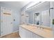 A bright bathroom offers a double sink vanity with a large mirror, plus multiple doorways to other rooms at 530 Summerhill Dr, Roswell, GA 30075