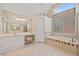 Bright bathroom with double sinks, a makeup vanity, and a soaking tub under a window for relaxing at 530 Summerhill Dr, Roswell, GA 30075