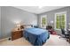 Well-lit bedroom with neutral walls, ceiling fan, desk and two large windows at 530 Summerhill Dr, Roswell, GA 30075