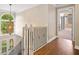 A bright hallway features hardwood floors, a decorative chandelier, and an open doorway to another room at 530 Summerhill Dr, Roswell, GA 30075