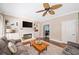 Bright living room with ceiling fan, fireplace, and built-in shelving and cabinets at 530 Summerhill Dr, Roswell, GA 30075