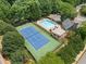Aerial view of a fenced community pool and tennis court surrounded by lush greenery at 530 Summerhill Dr, Roswell, GA 30075