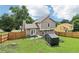 Backyard view of the home, storage shed, fenced yard, and open grassy area at 1126 Mainstreet Valley Dr, Stone Mountain, GA 30088
