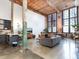 Open-concept living area with a modern kitchen, concrete floors, high ceilings, and exposed beams at 170 Boulevard Se # E117, Atlanta, GA 30312