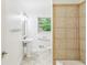 Bright bathroom with tiled shower, pedestal sink, tiled floors and a window at 3292 Ferncliff Ne Pl, Atlanta, GA 30324
