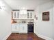 Basement bar area featuring white cabinets, a wine refrigerator, a sink, and plenty of countertop space at 3423 Jamont Blvd, Alpharetta, GA 30022