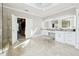 Bright primary bathroom featuring marble floors, double sinks, lighted mirrors, and access to a custom walk-in closet at 3423 Jamont Blvd, Alpharetta, GA 30022