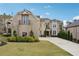 Stately brick home featuring manicured landscaping and a long, paved driveway on a sunny day at 3423 Jamont Blvd, Alpharetta, GA 30022