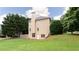 Rear exterior view of the home featuring a large yard, mature trees, and a partial sports court at 4045 Hillcrest View Ct, Suwanee, GA 30024