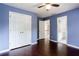 Bedroom with hardwood floors, blue painted walls, and access to an en-suite bathroom and closet at 4045 Hillcrest View Ct, Suwanee, GA 30024