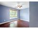 Bedroom featuring hardwood floors, ceiling fan, and a large window offering natural light at 4045 Hillcrest View Ct, Suwanee, GA 30024