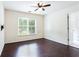 Bright bedroom featuring hardwood floors, ceiling fan, and a large window offering natural light at 4045 Hillcrest View Ct, Suwanee, GA 30024