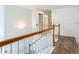 Hallway with wood railing, white spindles, and modern, wood-look vinyl flooring at 4045 Hillcrest View Ct, Suwanee, GA 30024
