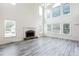 Spacious living room with a fireplace, large windows, and high ceilings with abundant natural light at 4045 Hillcrest View Ct, Suwanee, GA 30024