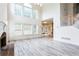 Bright living room with soaring ceilings, oversized windows, fireplace, and stairs to second level at 4045 Hillcrest View Ct, Suwanee, GA 30024