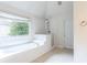 Bright bathroom featuring a large tub, separate shower, and natural light from the window at 4045 Hillcrest View Ct, Suwanee, GA 30024